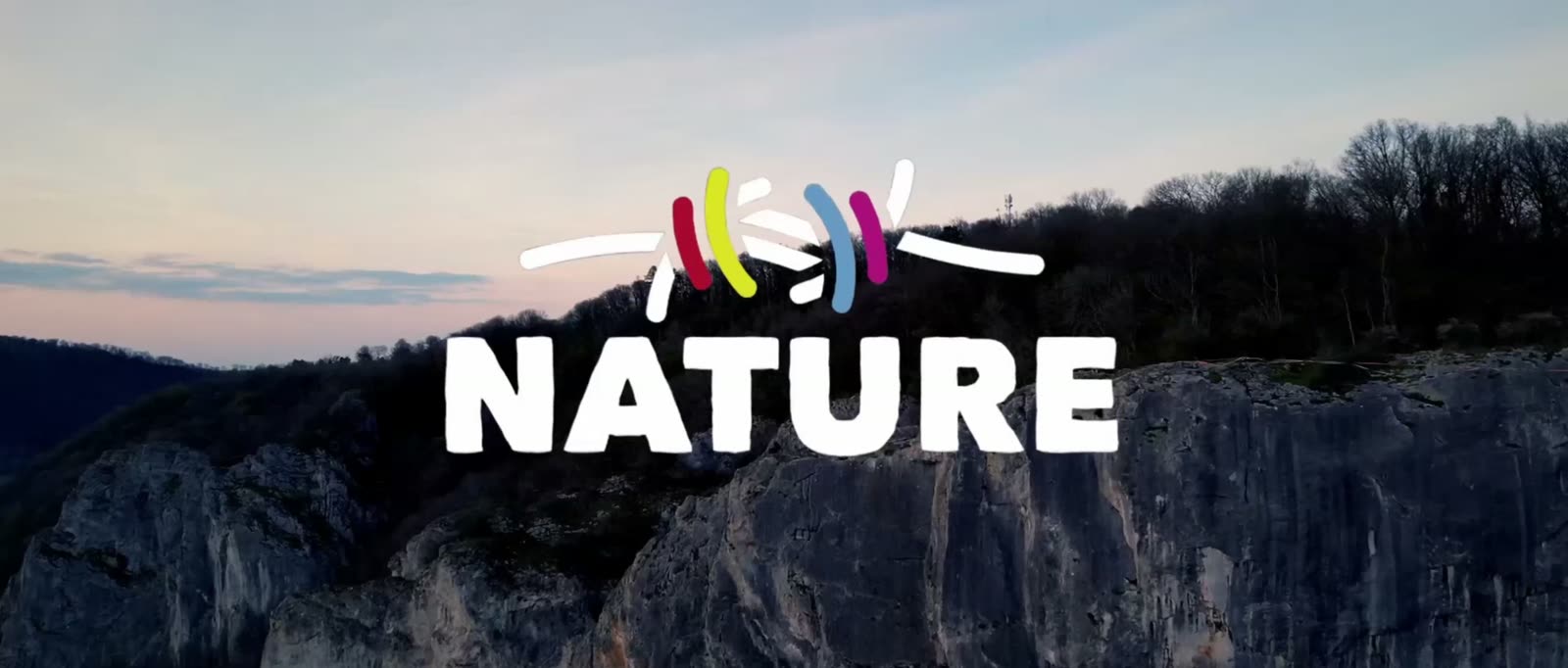 Beeld uit de film van NATURE: het logo boven een rotswand.